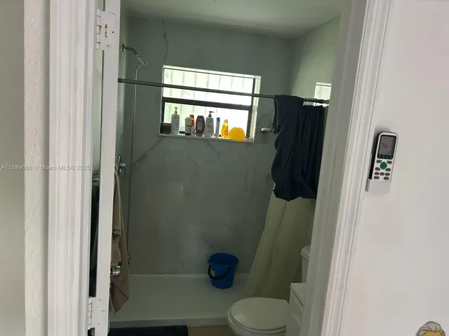 a bathroom with a toilet and a shower