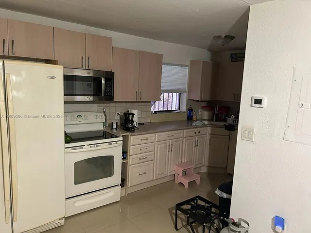 a kitchen with stainless steel appliances a stove microwave and a refrigerator