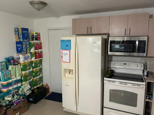 a kitchen with stainless steel appliances white cabinets and a refrigerator