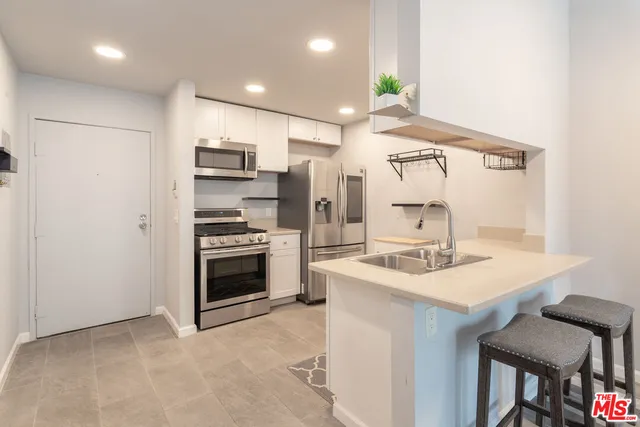 a kitchen with stainless steel appliances a sink stove and refrigerator