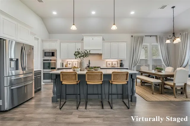 a dining room with stainless steel appliances granite countertop furniture wooden floor and a view of kitchen
