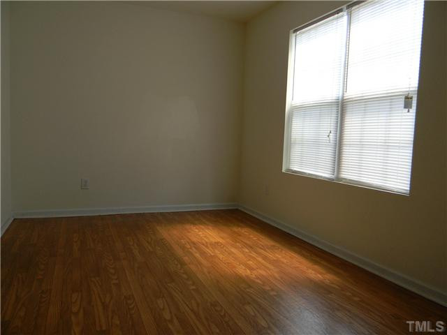 1315 East Lane Street, Unit 2 Raleigh, NC 27610 - Photo 4 of 11 a view of an empty room with wooden floor and a window