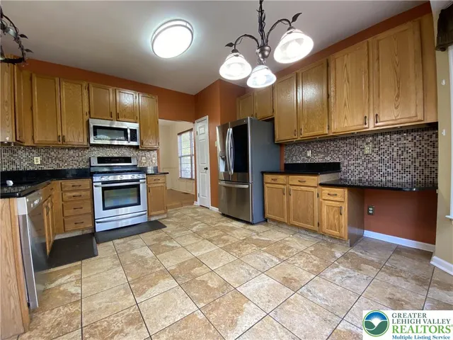a kitchen with stainless steel appliances granite countertop a stove cabinets and refrigerator