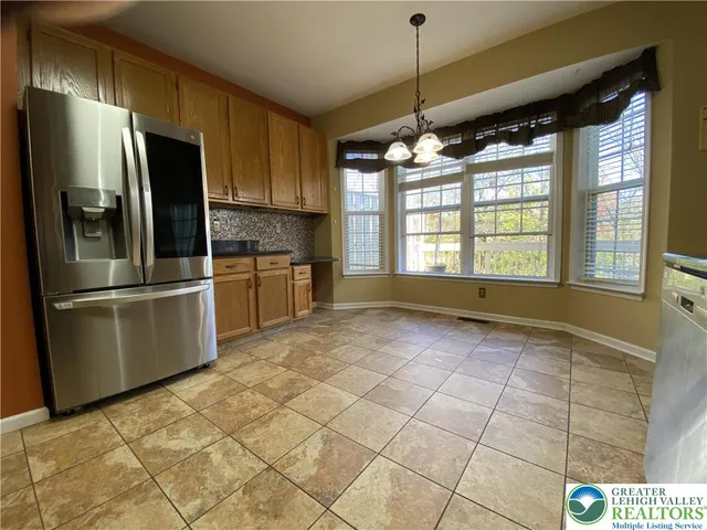 a kitchen with stainless steel appliances granite countertop a refrigerator a oven a sink a stove and a refrigerator