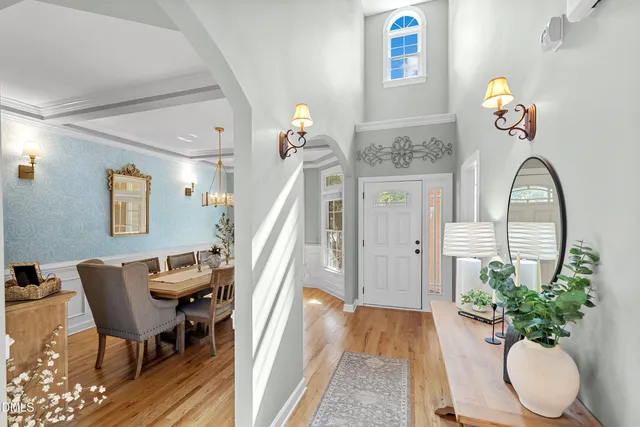 a dining room with furniture a chandelier and wooden floor