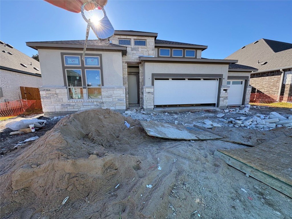 View of front of house with stone siding and stucco siding