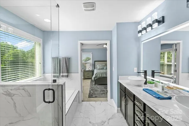 a bathroom with a granite countertop sink a large mirror and a bathtub