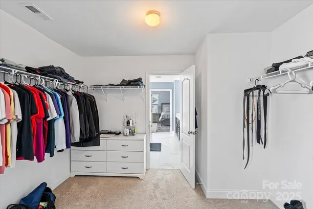 a view of walk in closet with clothes and shoes