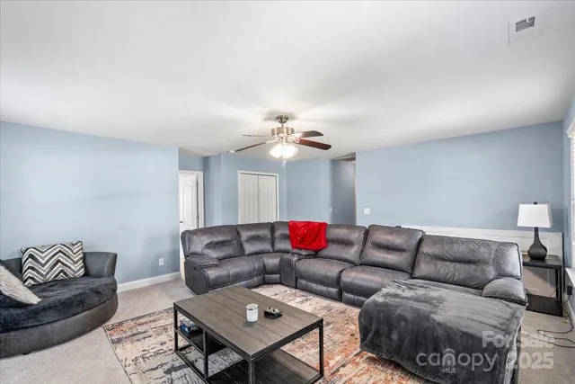 a living room with furniture and a ceiling fan