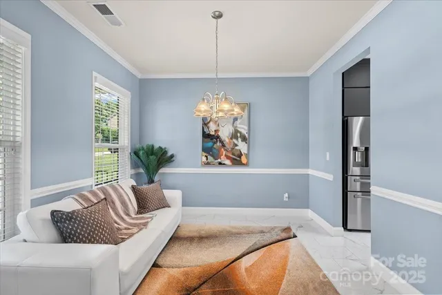 a living room with furniture and a chandelier