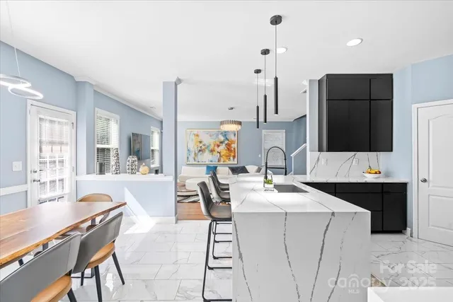 a kitchen with a sink a stove a refrigerator and chairs