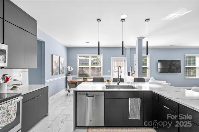 a kitchen with kitchen island granite countertop a sink appliances and cabinets