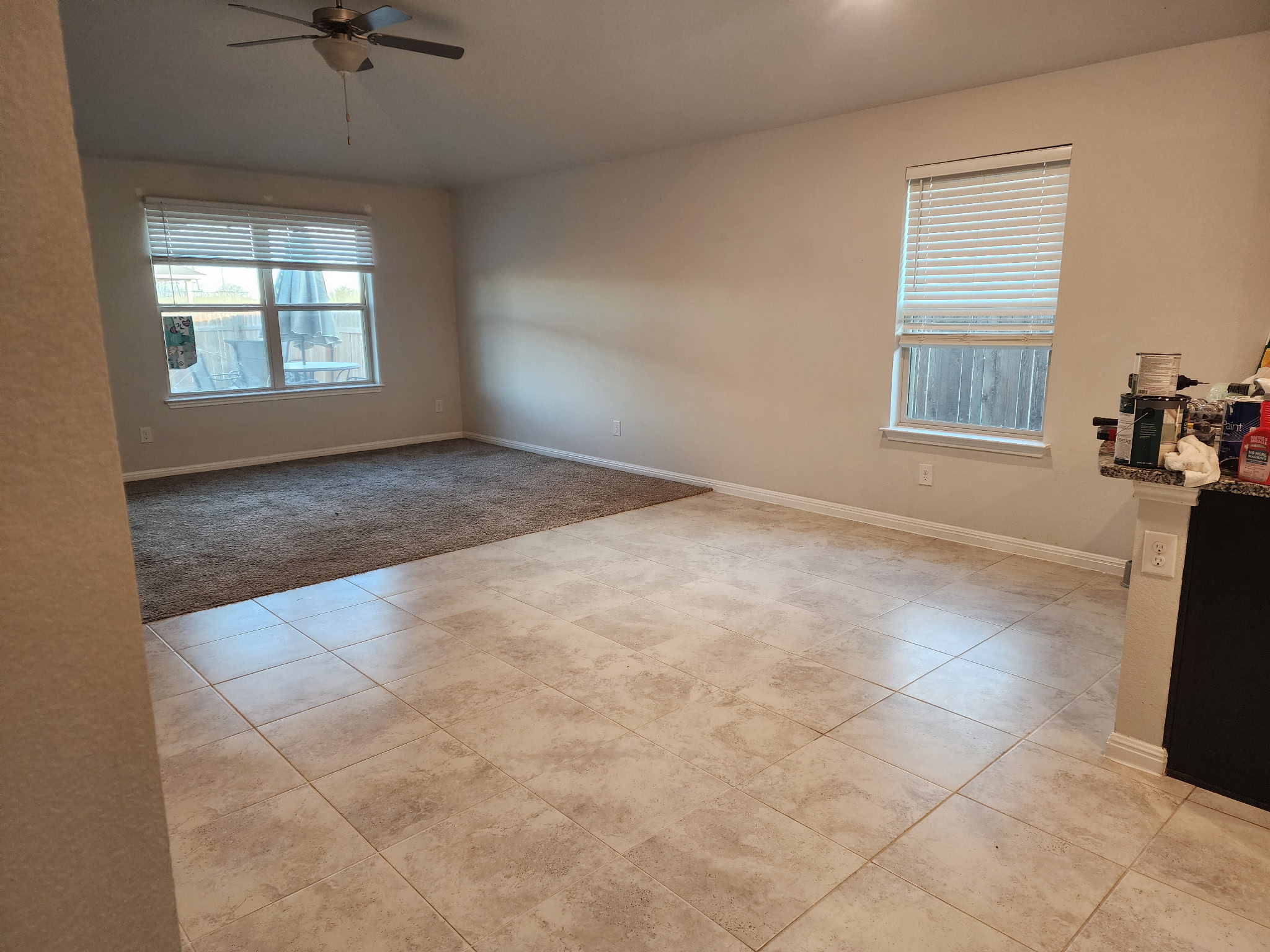 12321 Caldera Way Manor, TX 78653 - Photo 10 of 18 Empty room featuring light tile patterned floors, a ceiling fan, light carpet, and lofted ceiling