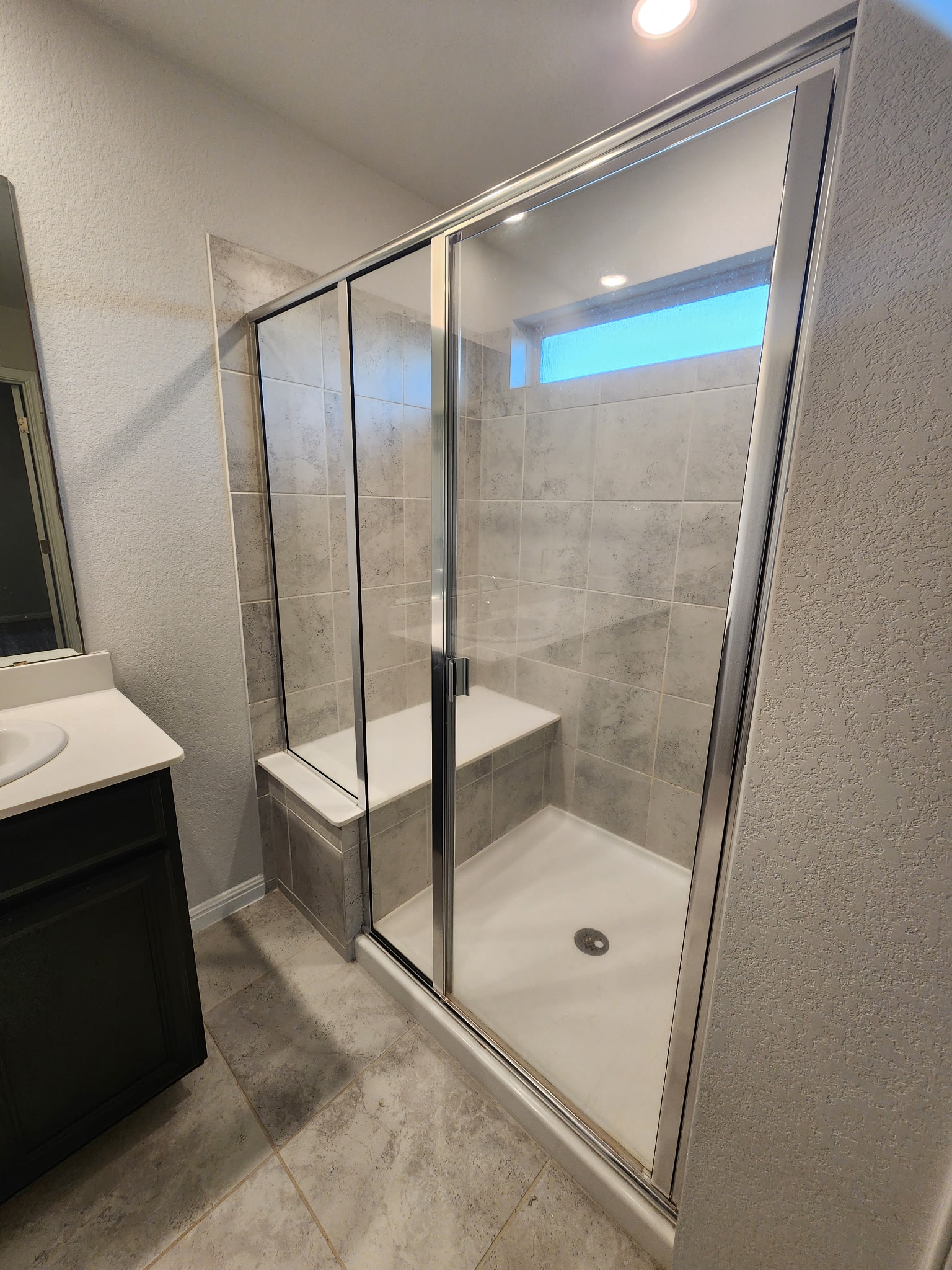 12321 Caldera Way Manor, TX 78653 - Photo 16 of 18 Bathroom with a textured wall, a stall shower, vanity, and light tile patterned flooring
