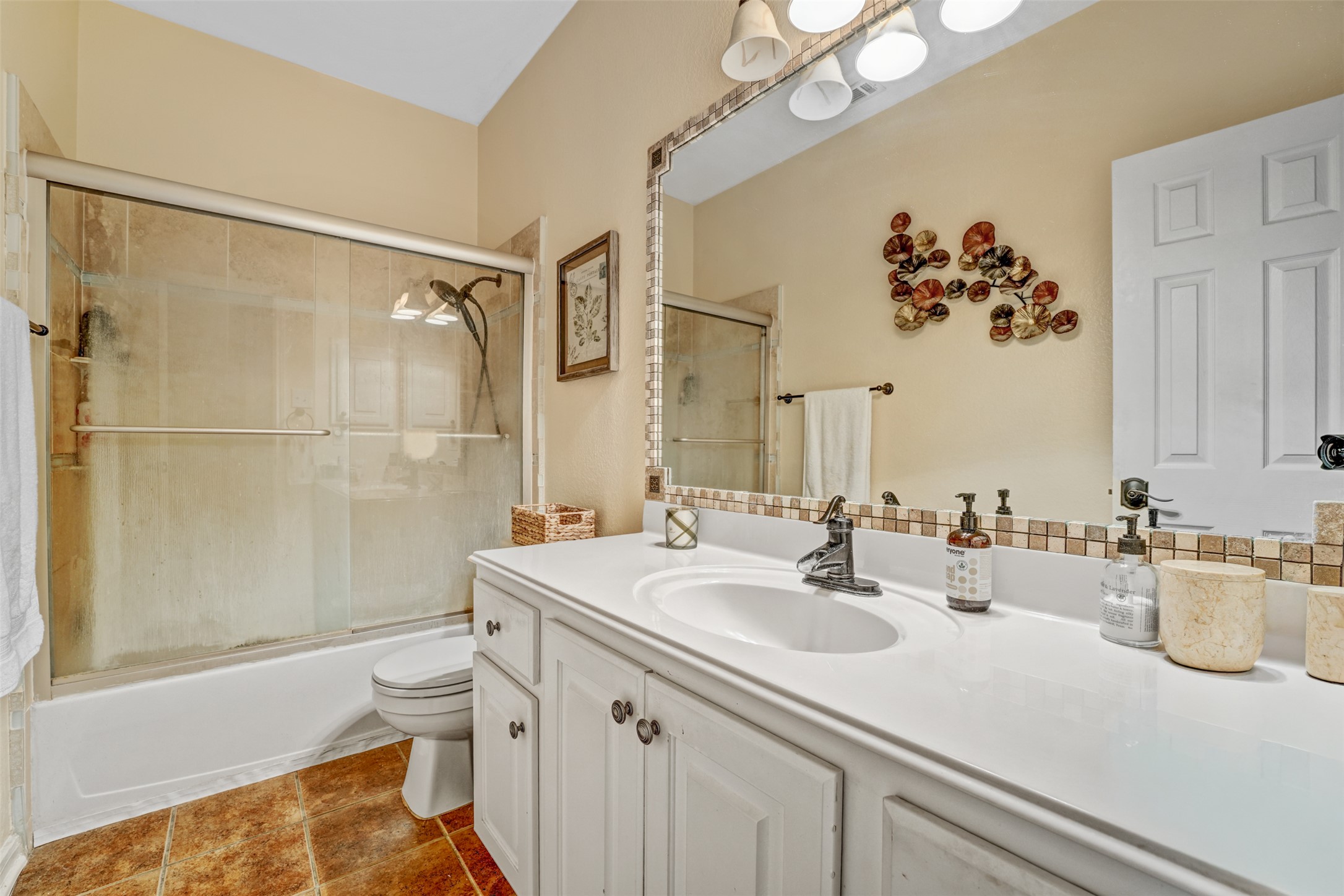 2521 Amen Corner Road Pflugerville, TX 78660 - Photo 30 of 40 Full bathroom featuring a white vanity with integrated sink, a tiled backsplash, and a framed mirror