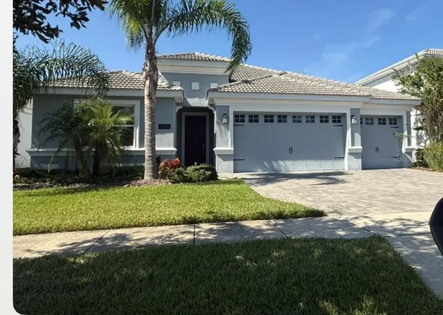 a view of a house with a yard and palm trees