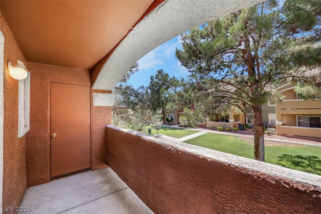 8101 West Flamingo Road, Unit 2136 Las Vegas, NV 89147 - Photo 29 of 32 Mature trees frame the view from this private covered concrete balcony overlooking manicured lawns.