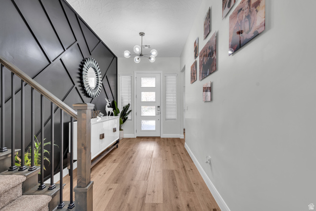 6105 Bunda Way St. George, UT 84790 - Photo 3 of 49 Entryway featuring a contemporary geometric accent wall and wood-finish flooring