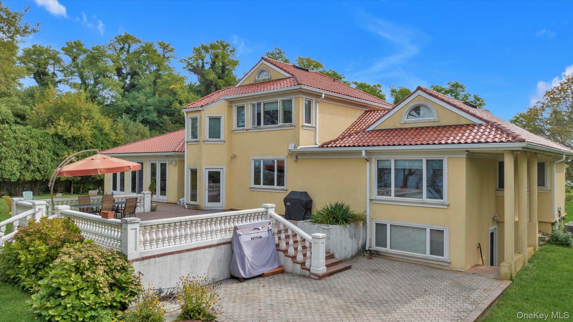 3400 Dignans Road Cutchogue, NY 11935 - Photo 50 of 50 Back of property featuring stucco siding, a wooden deck, outdoor dining area, and a tile roof