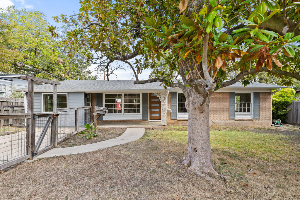 front view of a house with a large tree