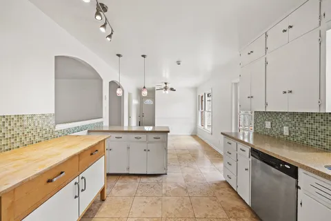 a large white kitchen with a stove a sink dishwasher and a refrigerator