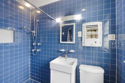 a bathroom with a toilet a sink and mirror