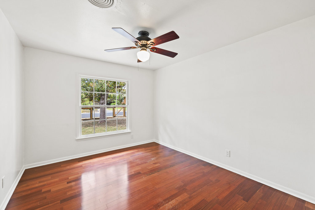 1502 Ridgehaven Drive Austin, TX 78723 - Photo 18 of 34 an empty room with wooden floor fan and windows