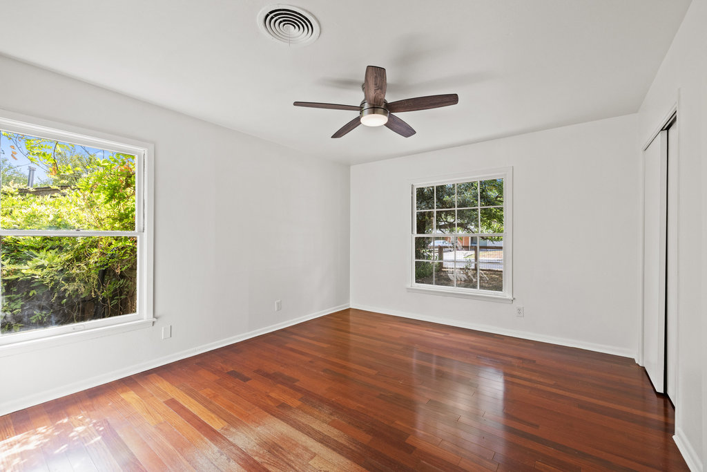 1502 Ridgehaven Drive Austin, TX 78723 - Photo 29 of 34 a view of an empty room with wooden floor and a window
