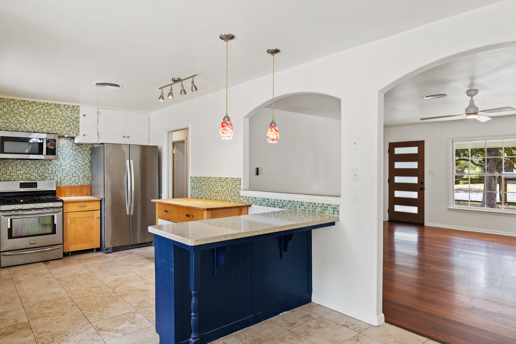 1502 Ridgehaven Drive Austin, TX 78723 - Photo 10 of 34 a kitchen with stainless steel appliances granite countertop a refrigerator a sink dishwasher and a stove with wooden floor