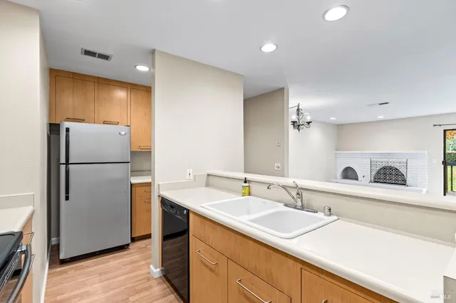 a kitchen with a sink refrigerator and cabinets