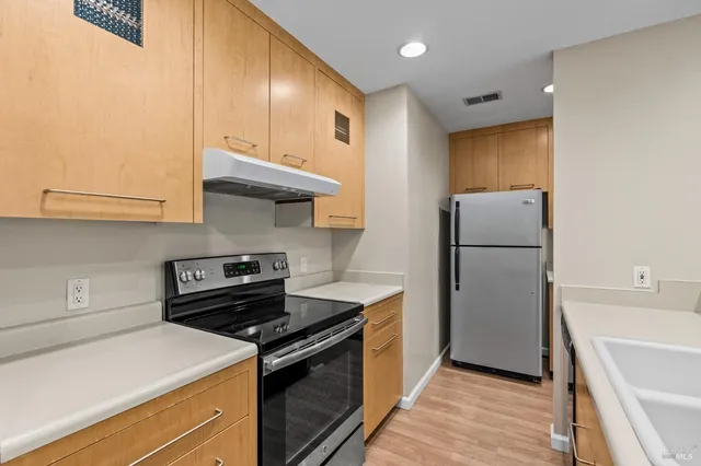 a kitchen with a refrigerator a stove and a sink