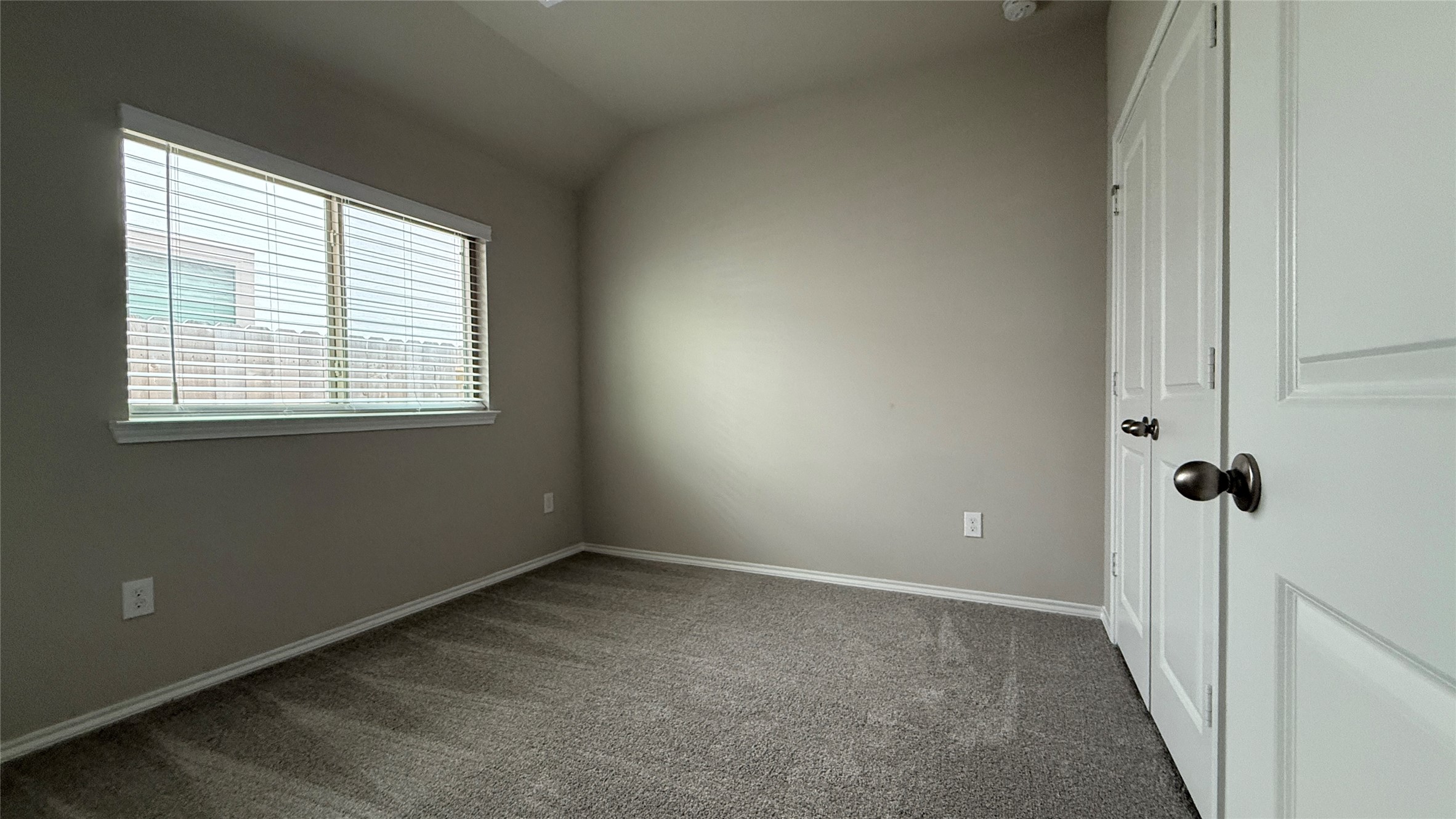 31961 Retama Rnch Drive Spring, TX 77386 - Photo 14 of 25 This room features neutral-colored walls and carpet, with a large window providing natural light. It has a closet with double doors, making it a practical space for a bedroom or office.