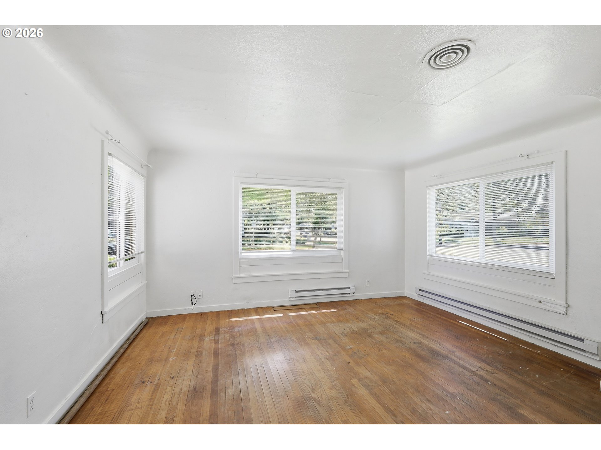 2189 Hilyard Street Eugene, OR 97405 - Photo 4 of 39 a view of an empty room with wooden floor and a window
