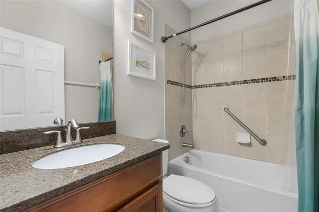 a bathroom with a granite countertop sink toilet and shower