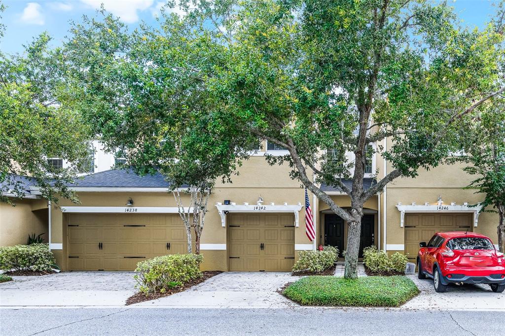 14242 Desert Haven Street, Unit GE Windermere, FL 34786 - Photo 2 of 32 a front view of a house with a yard and garage