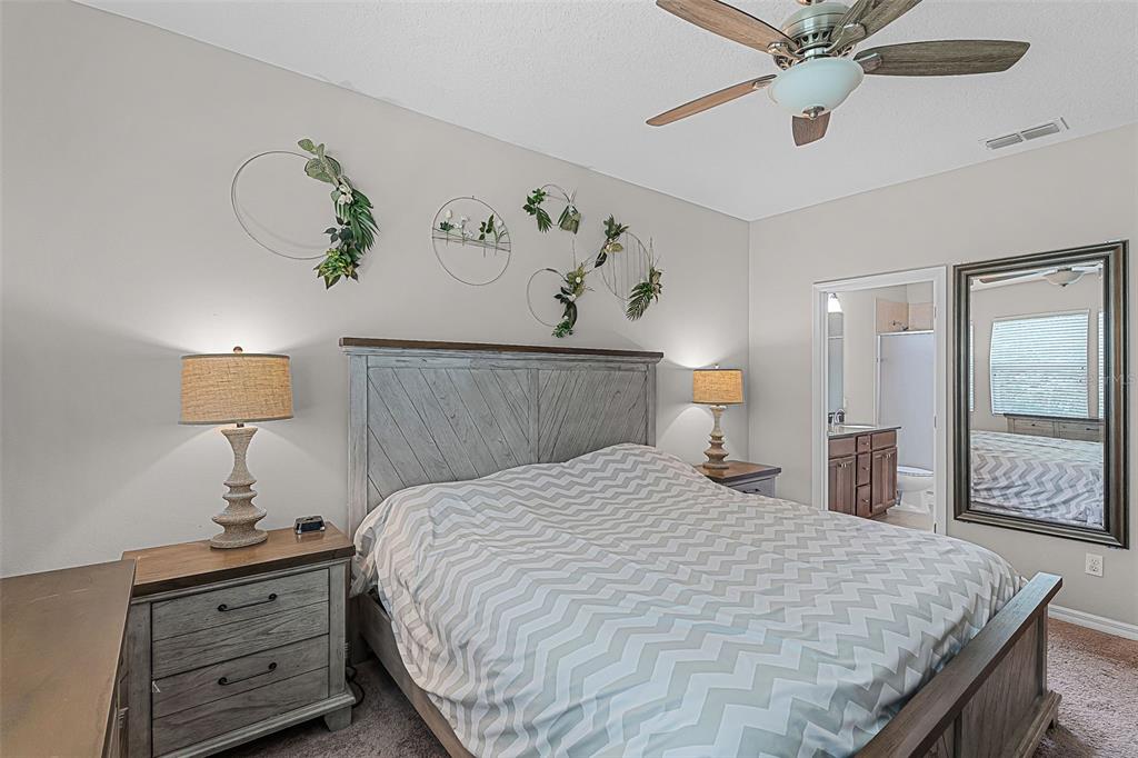 14242 Desert Haven Street, Unit GE Windermere, FL 34786 - Photo 25 of 32 a bedroom with a bed and a chandelier