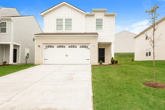 a view of a white house next to a yard and yard