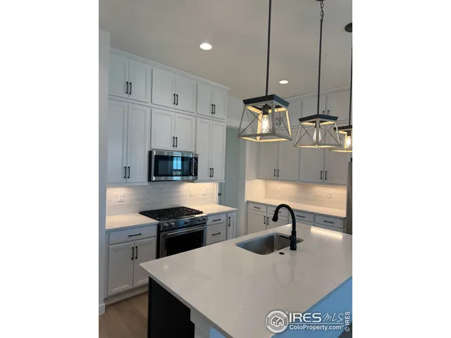 a kitchen with stainless steel appliances granite countertop a sink a stove and a refrigerator