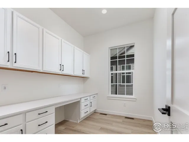 a kitchen with white cabinets and window