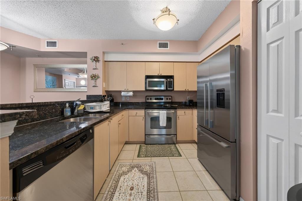 1105 Reserve Court, Unit 206 Naples, FL 34105 - Photo 5 of 23 a kitchen with a sink cabinets and stainless steel appliances