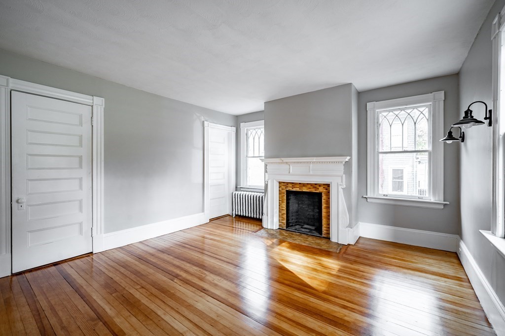 110 Mill Street Springfield, MA 01108 - Photo 25 of 41 a view of an empty room with wooden floor fireplace and a window