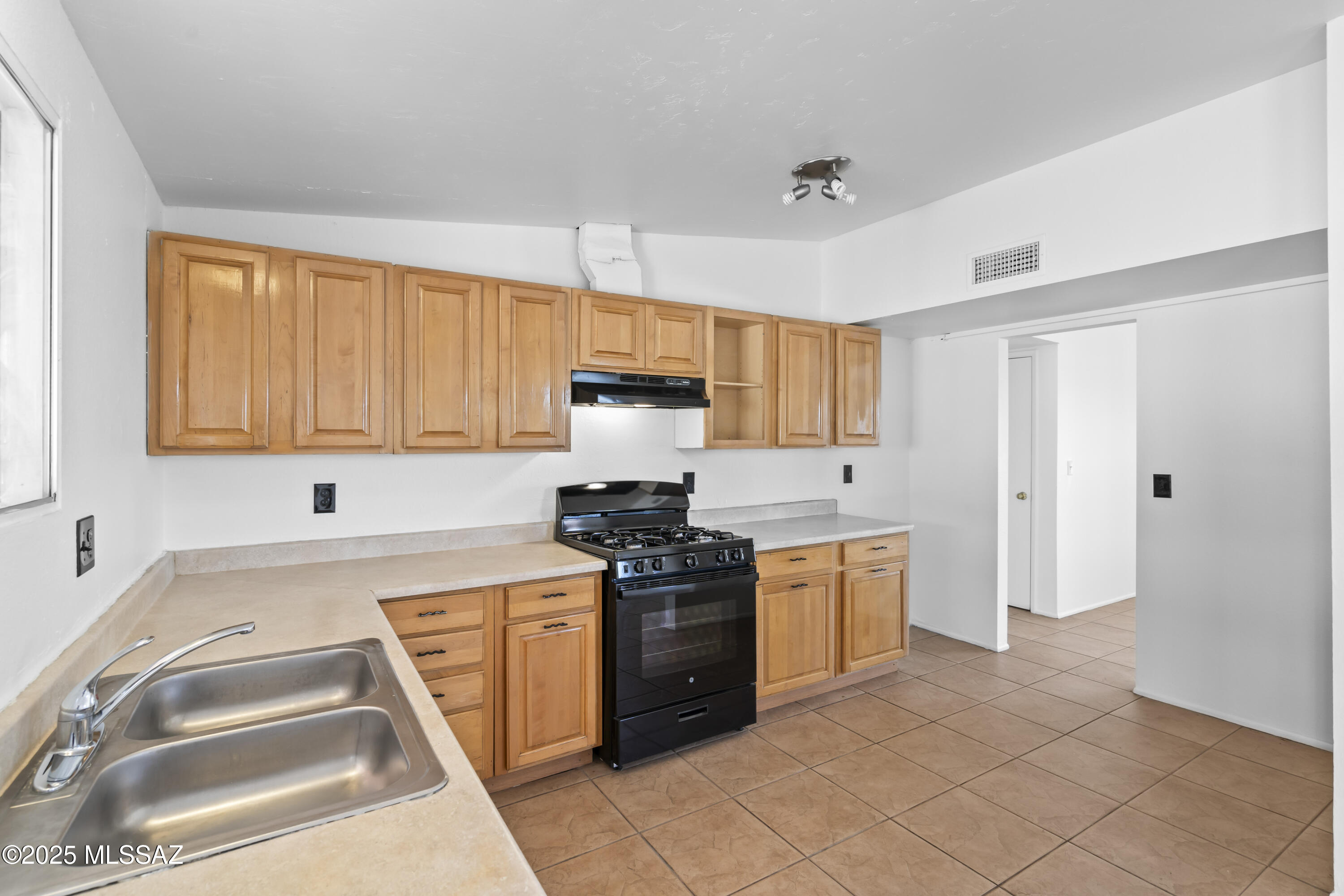 1926 West Saxony Road Tucson, AZ 85713 - Photo 12 of 26 a kitchen with stainless steel appliances granite countertop a stove a sink and a refrigerator