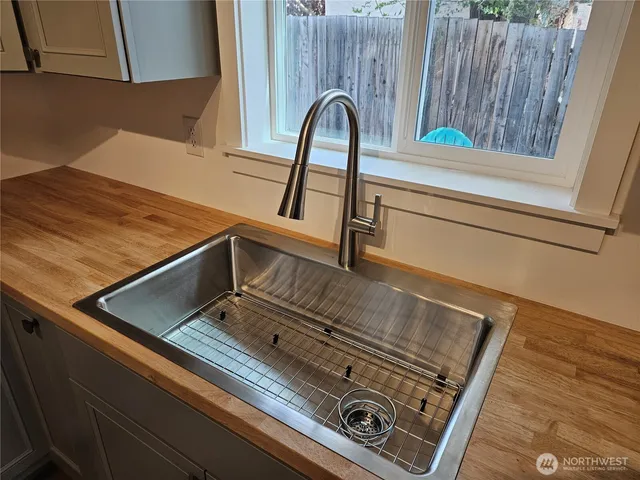 a view of a hallway with wooden floor and a bathroom