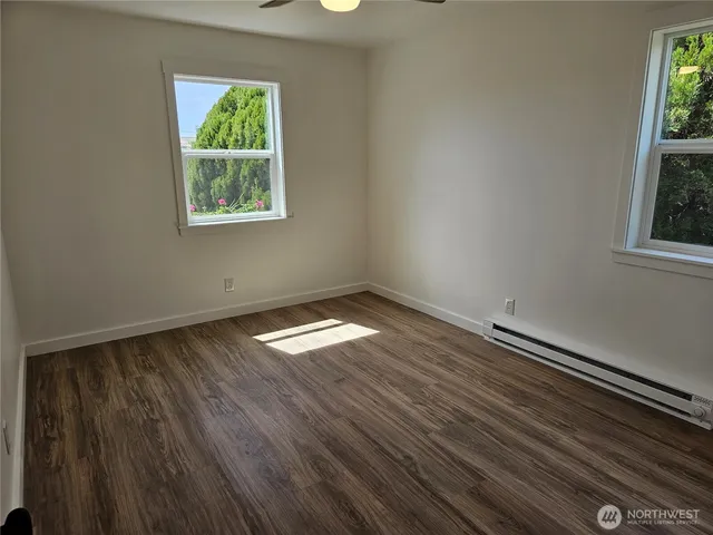 a view of an empty room with wooden floor
