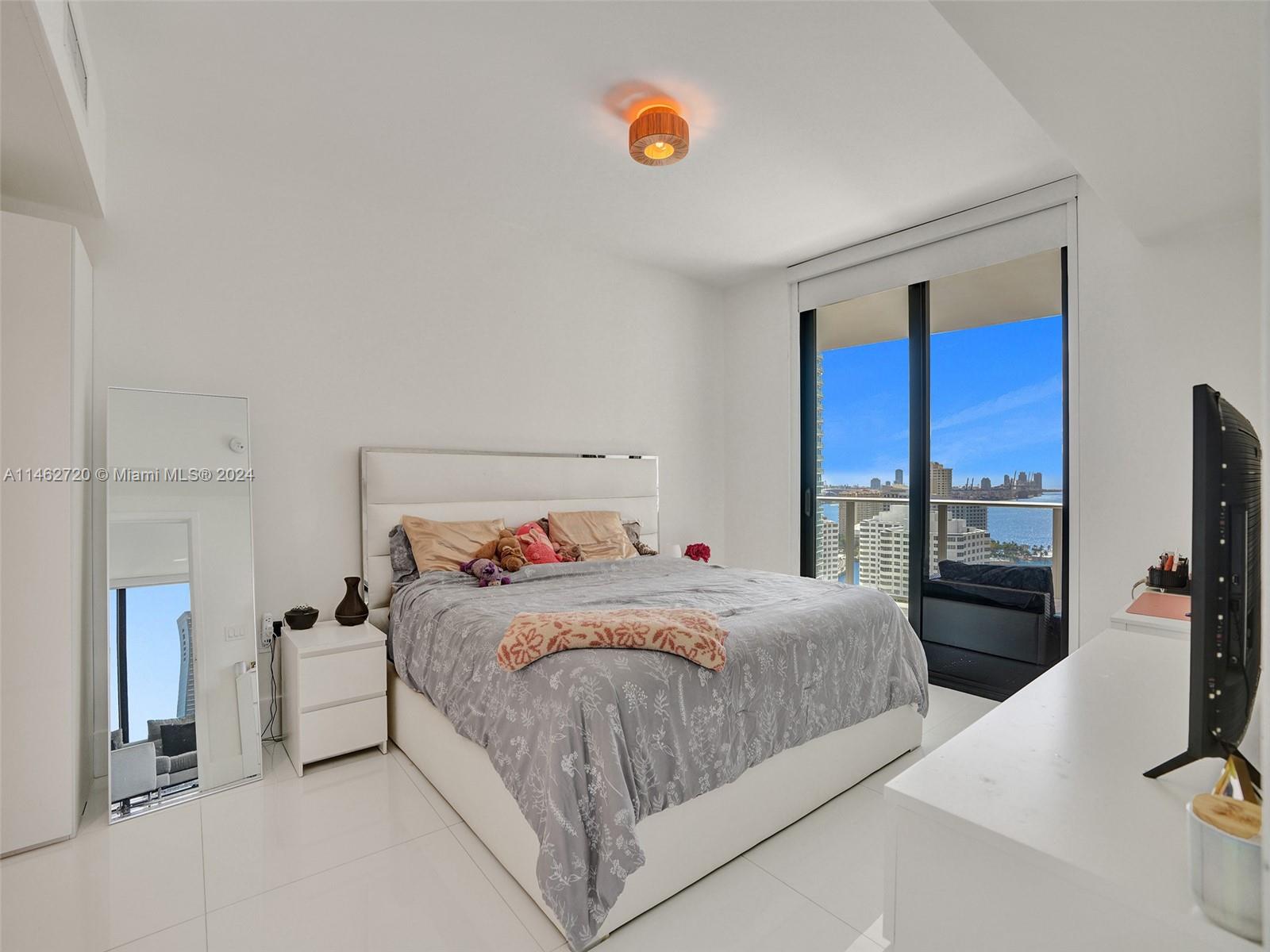 1010 Brickell Avenue, Unit 2505 Miami, FL 33131 - Photo 17 of 61 a bedroom with a bed and a flat tv screen on dresser