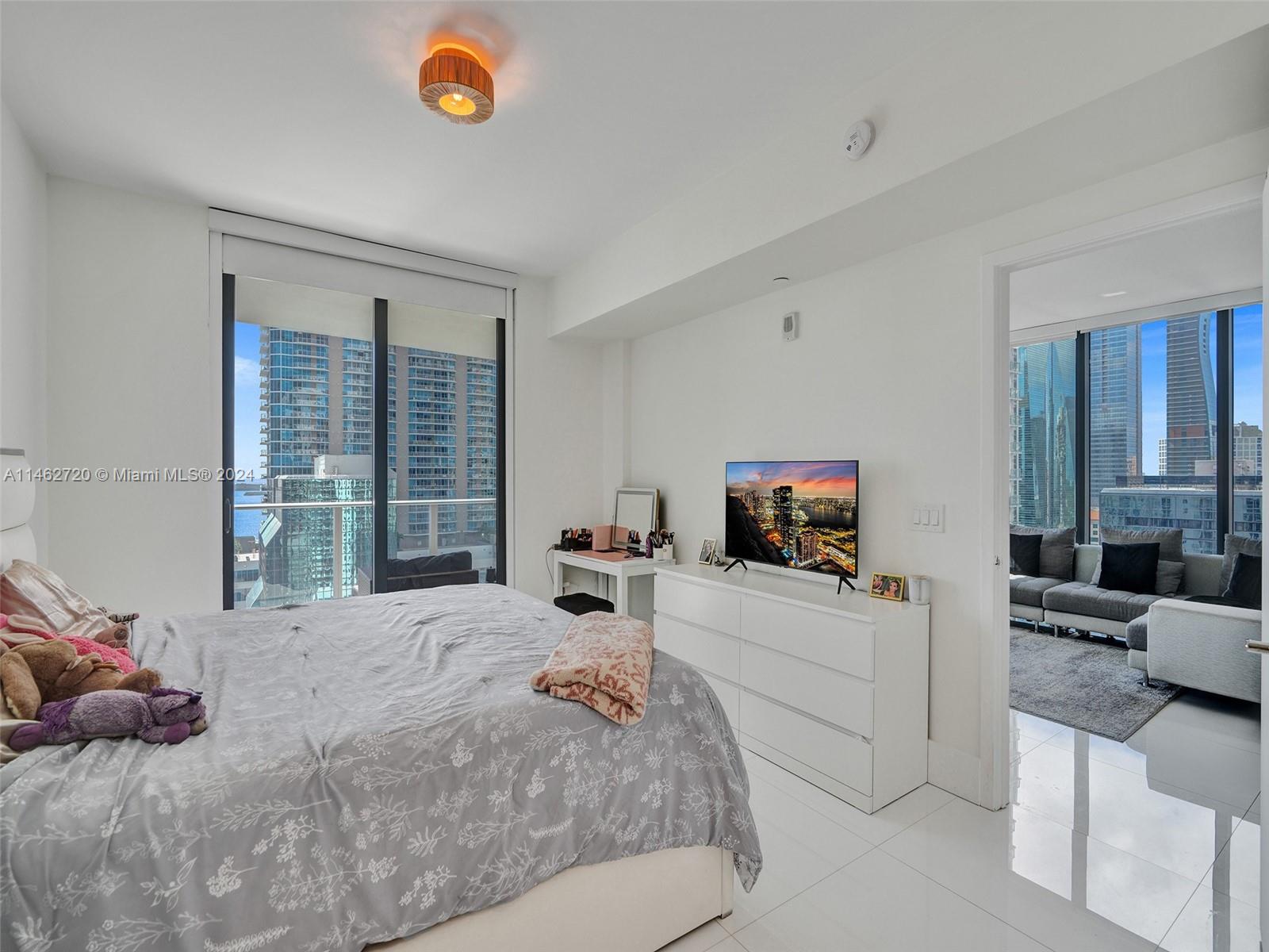1010 Brickell Avenue, Unit 2505 Miami, FL 33131 - Photo 20 of 61 a bedroom with a bed a couch and a flat screen tv