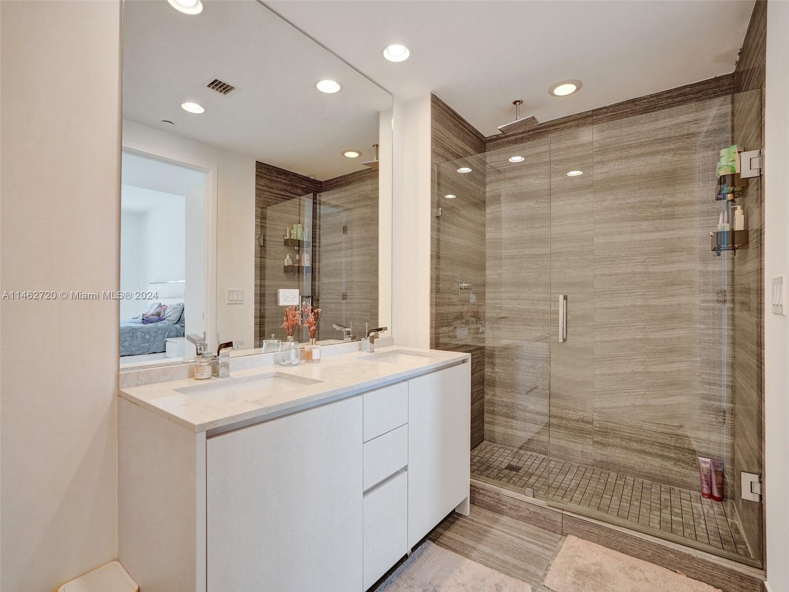 1010 Brickell Avenue, Unit 2505 Miami, FL 33131 - Photo 28 of 61 a bathroom with a double vanity sink mirror and shower
