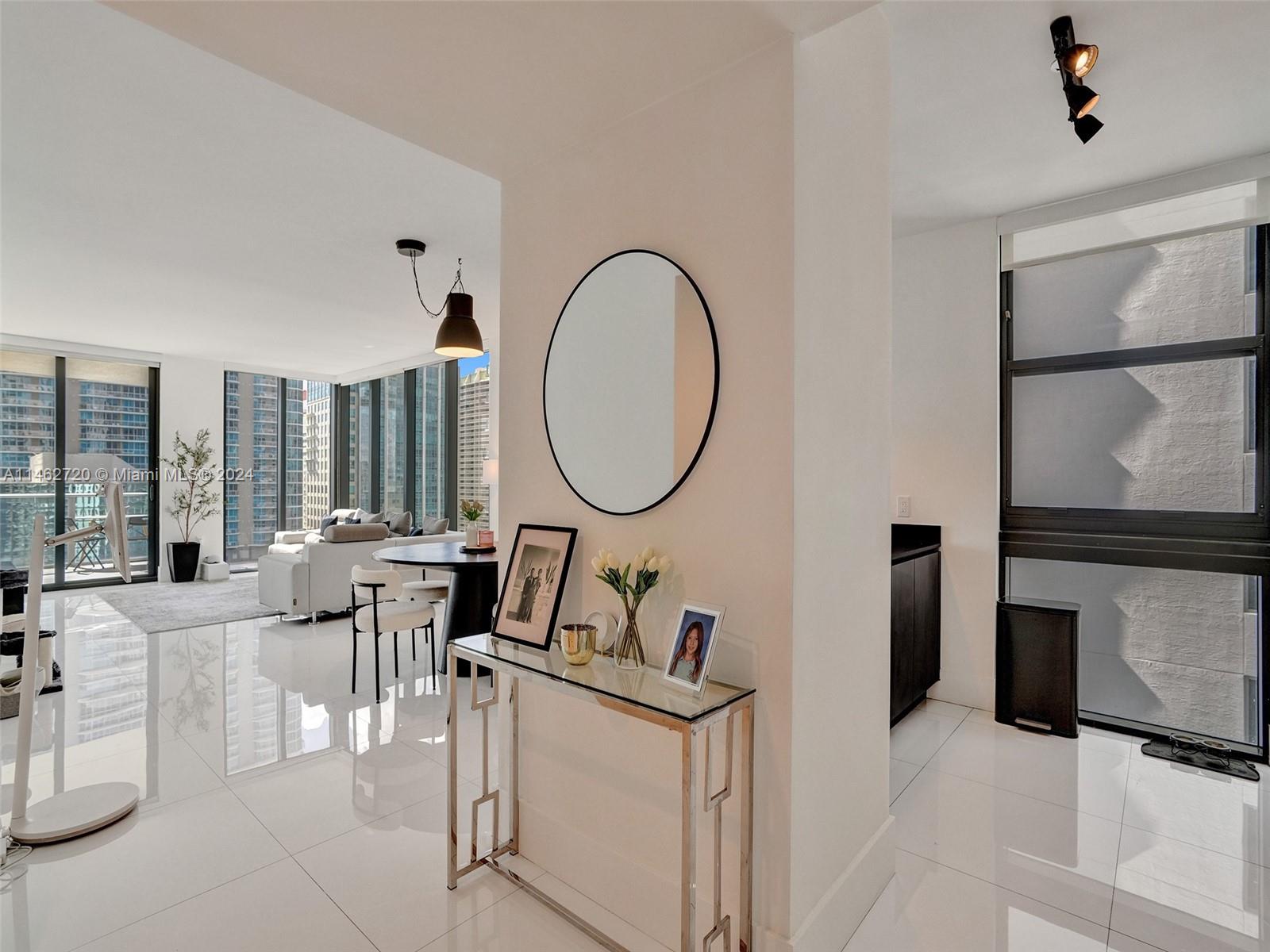 1010 Brickell Avenue, Unit 2505 Miami, FL 33131 - Photo 3 of 61 a living room with furniture a mirror and a fireplace