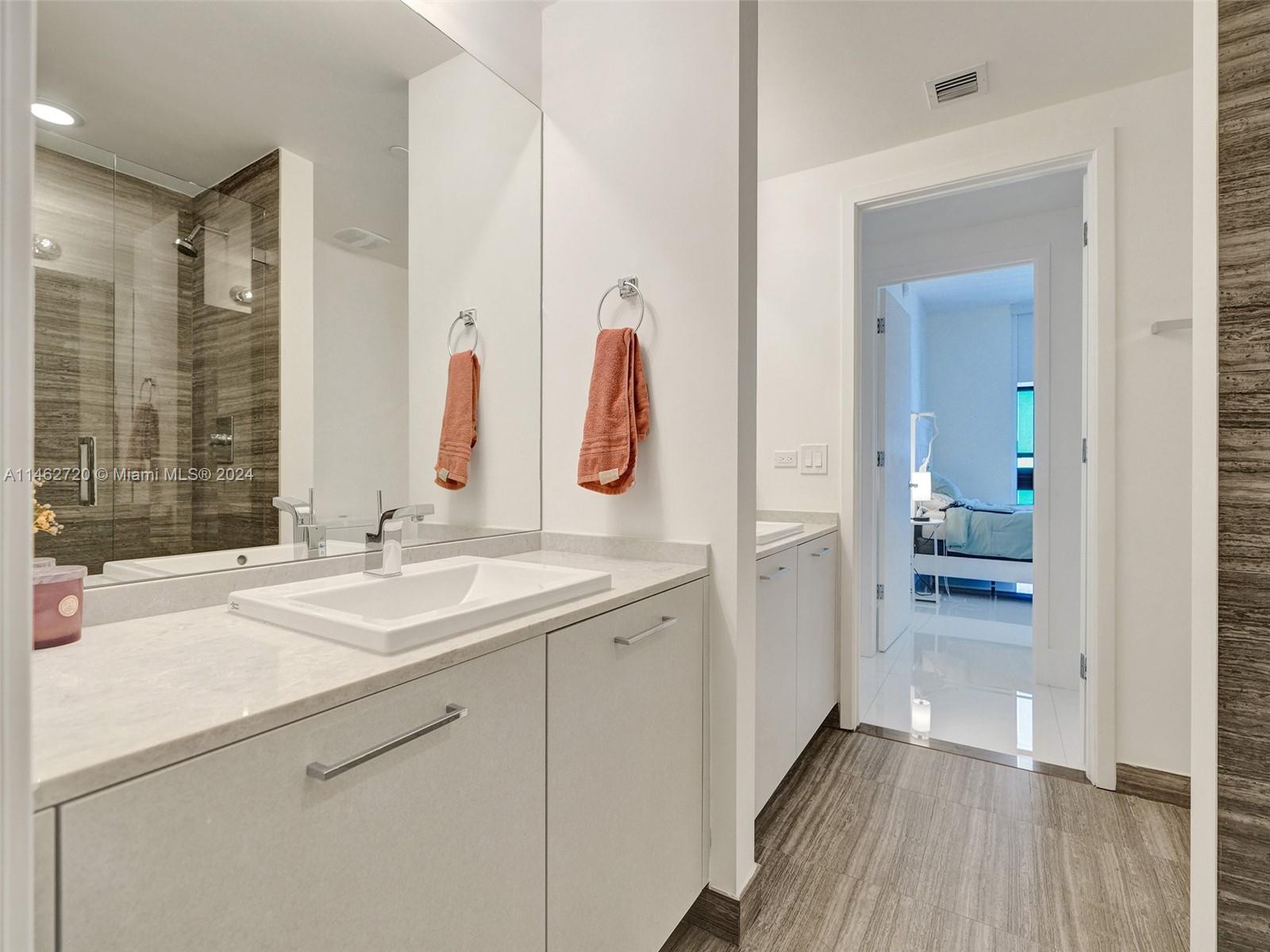 1010 Brickell Avenue, Unit 2505 Miami, FL 33131 - Photo 32 of 61 a en suite bathroom with a sink and a mirror