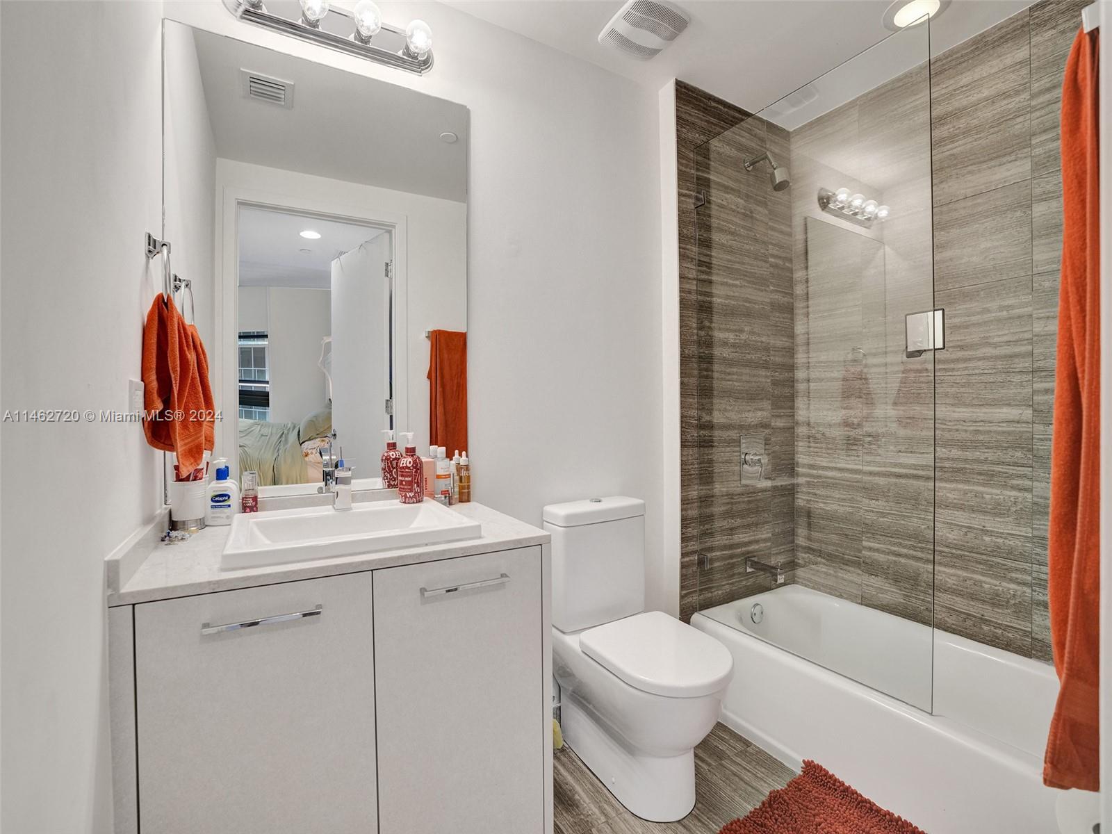 1010 Brickell Avenue, Unit 2505 Miami, FL 33131 - Photo 35 of 61 a bathroom with a bathtub shower sink vanity mirror and toilet